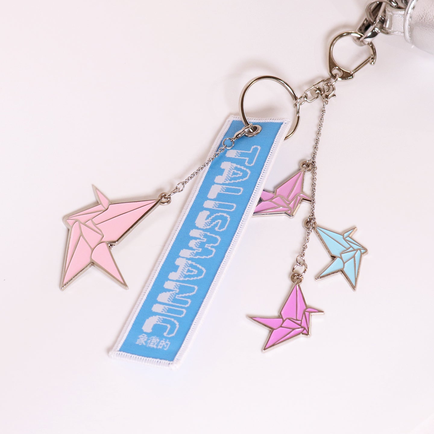 Keychain with pink and blue origami-style charms on a white background